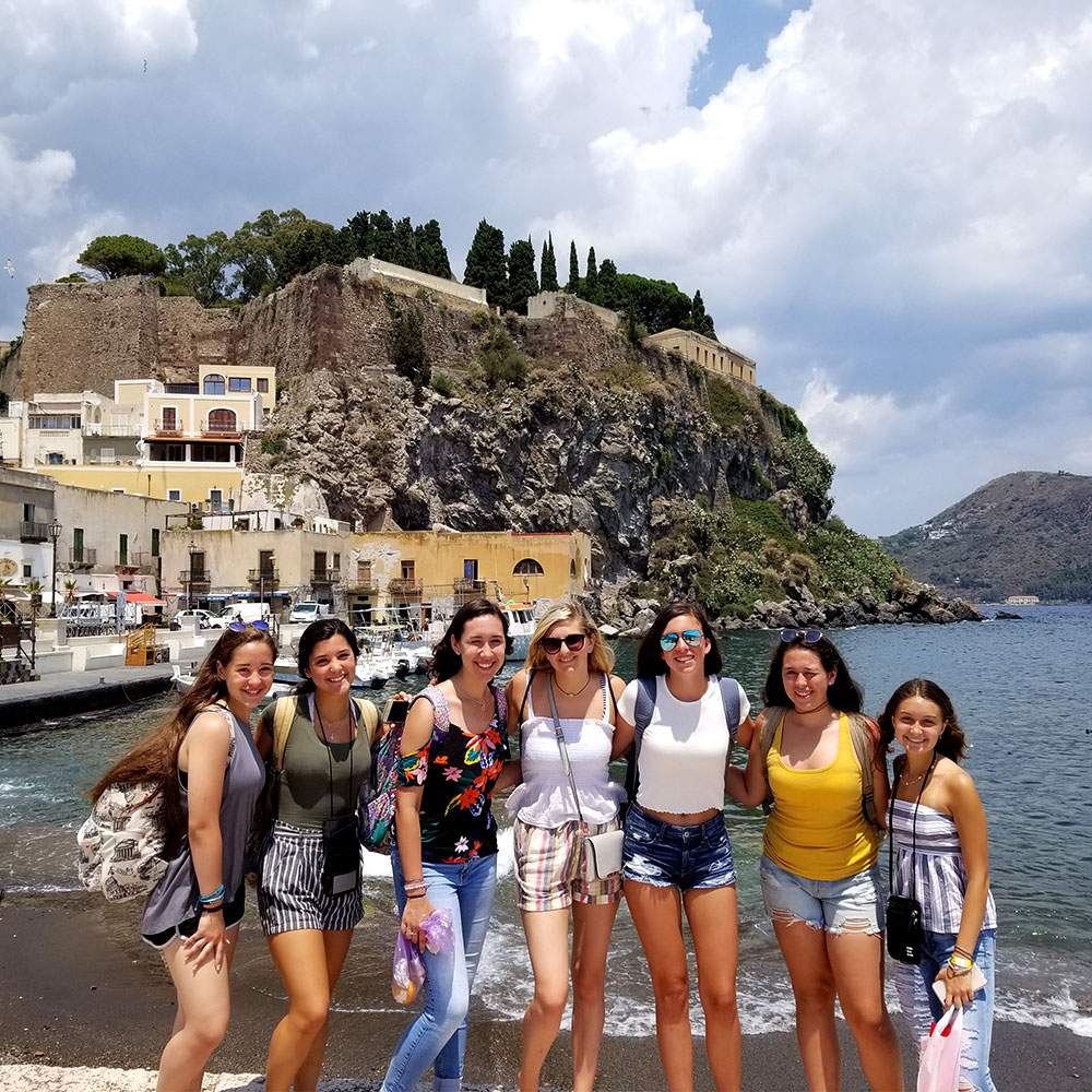 waterside with seven teenage girls ready for an educational tour of Italy